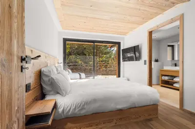 a bedroom with a large bed and a window at Chalet Rémond - Vue Montagnes in Chamonix-Mont-Blanc
