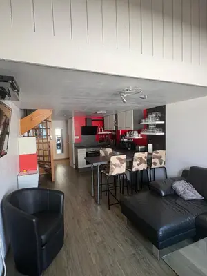 a living room and kitchen with a couch and a table at Triplex de 42m2 proche piste retour de St-Gervais in Saint-Gervais-les-Bains