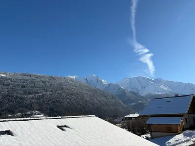 a view of a snow covered mountain with a building at Triplex de 42m2 proche piste retour de St-Gervais in Saint-Gervais-les-Bains