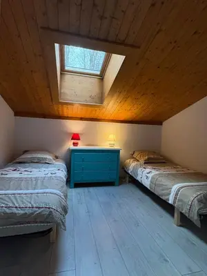two beds in a room with a skylight at Triplex de 42m2 proche piste retour de St-Gervais in Saint-Gervais-les-Bains