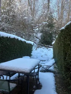 a table and chairs covered in snow next to a hedge at Triplex de 42m2 proche piste retour de St-Gervais in Saint-Gervais-les-Bains