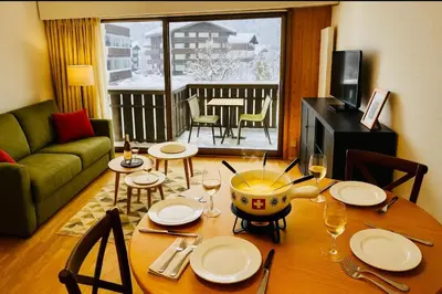 a living room with a table with plates and wine glasses at Bright apartment in the heart of Chamonix in Chamonix-Mont-Blanc