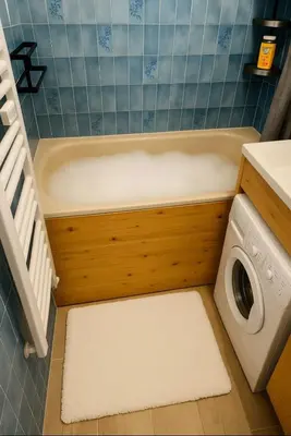 a bathroom with a tub and a washing machine at Bright apartment in the heart of Chamonix in Chamonix-Mont-Blanc