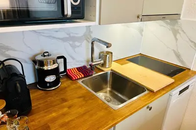 a kitchen counter with a sink and a microwave at Bright apartment in the heart of Chamonix in Chamonix-Mont-Blanc