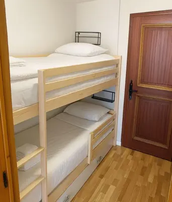 a bedroom with two bunk beds and a door at Bright apartment in the heart of Chamonix in Chamonix-Mont-Blanc