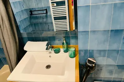 a bathroom with a white sink and blue tiles at Bright apartment in the heart of Chamonix in Chamonix-Mont-Blanc