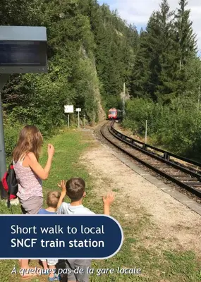 a woman and two children are looking at a train at Les Grands Tetras in Les Houches