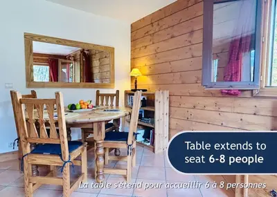 a dining room with a table and chairs and a mirror at Les Grands Tetras in Les Houches