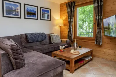 a living room with a couch and a table at Les Sonnailles Apartment - Chamonix All Year in Chamonix-Mont-Blanc