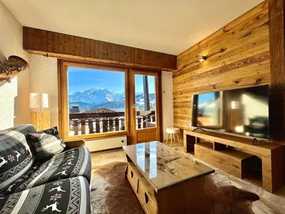 a living room with a couch and a large window at The Balcony of the Giant in Combloux in Combloux