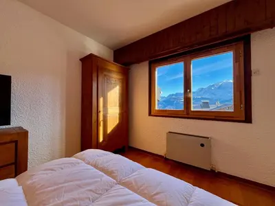 a bedroom with a bed and a large window at The Balcony of the Giant in Combloux in Combloux