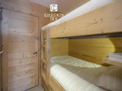 a bedroom with two bunk beds in a wooden room at Studio cabine cosy Megève parking gratuit in Megève