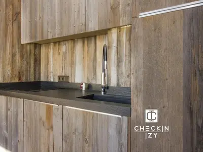 a kitchen with a sink in a wooden wall at Studio cabine cosy Megève parking gratuit in Megève