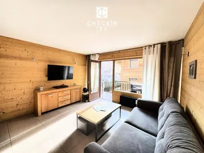 a living room with a couch and a tv at Studio cabine cosy Megève parking gratuit in Megève