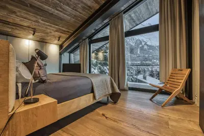 a bedroom with a bed and a large window at Sumptuous Chalet In Chamonix-Mont-Blanc in Chamonix-Mont-Blanc