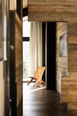 a wooden room with a chair in front of a window at Sumptuous Chalet In Chamonix-Mont-Blanc in Chamonix-Mont-Blanc