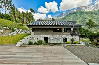 a stone building with mountains in the background at Sumptuous Chalet In Chamonix-Mont-Blanc in Chamonix-Mont-Blanc