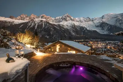a hot tub on a deck with snow covered mountains at Sumptuous Chalet In Chamonix-Mont-Blanc in Chamonix-Mont-Blanc