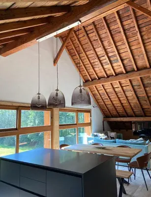 a kitchen with a table in a room with windows at Maison du Tailleur de Pierre, 5 bedroom apartment, 3 bathrooms, ski-bus, parking in Samoëns