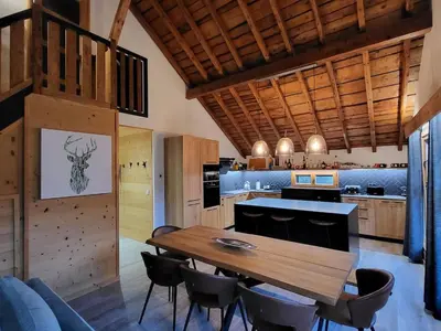 a large kitchen with a wooden table and chairs at Maison du Tailleur de Pierre, 5 bedroom apartment, 3 bathrooms, ski-bus, parking in Samoëns