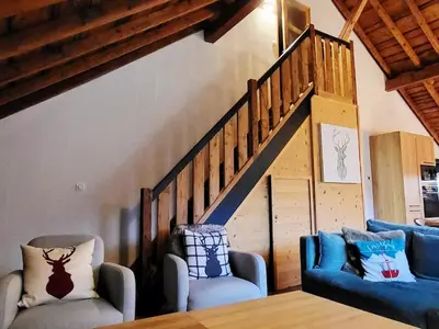 a living room with two chairs and a staircase at Maison du Tailleur de Pierre, 5 bedroom apartment, 3 bathrooms, ski-bus, parking in Samoëns