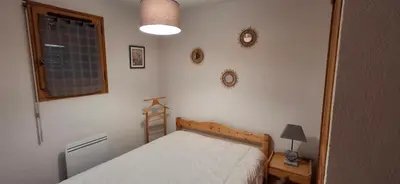 a small bedroom with a bed and a window at Bel appartement in Samoëns