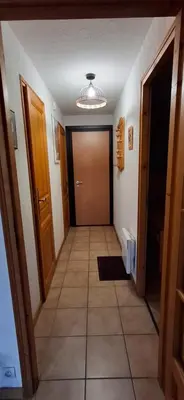 a kitchen with a table and chairs in a room at Bel appartement in Samoëns