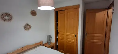a bedroom with a bed and a wooden door at Bel appartement in Samoëns