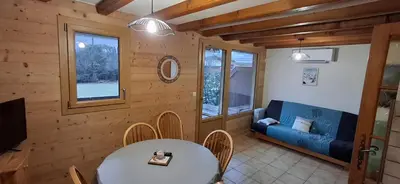 a living room with a table and a blue couch at Bel appartement in Samoëns