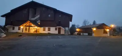 a large building with a parking lot in front of it at Bel appartement in Samoëns