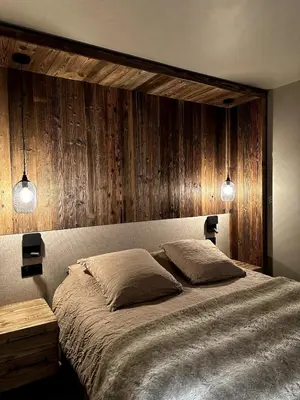 a bedroom with a large bed with wooden walls at Appartement cosy proche du centre de Megève in Megève