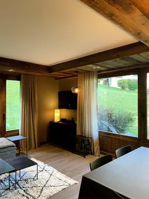a living room with a table and a large window at Appartement cosy proche du centre de Megève in Megève