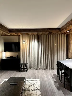 a living room with a table and a large curtain at Appartement cosy proche du centre de Megève in Megève