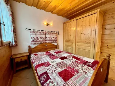 a bedroom with a bed with a quilt on it at Confortable T2 avec jardin, animaux acceptés - FR-1-624-188 in Samoëns
