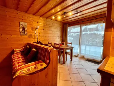 a living room with a couch and a table in a cabin at Confortable T2 avec jardin, animaux acceptés - FR-1-624-188 in Samoëns
