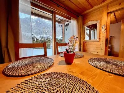a wooden table with three chairs and a vase on it at Confortable T2 avec jardin, animaux acceptés - FR-1-624-188 in Samoëns