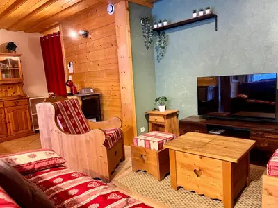 a living room with a couch and a flat screen tv at Confortable T2 avec jardin, animaux acceptés - FR-1-624-188 in Samoëns