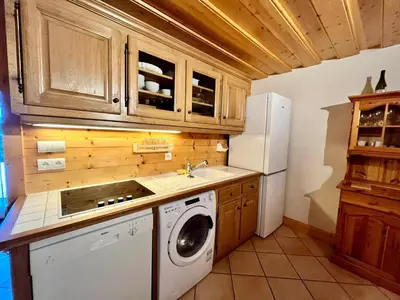 a kitchen with a washing machine and a refrigerator at Confortable T2 avec jardin, animaux acceptés - FR-1-624-188 in Samoëns