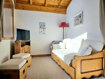 a bedroom with a wooden bed and a television at Charming sunny duplex in Megève