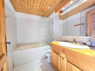 a bathroom with a sink and a tub and a toilet at Charming sunny duplex in Megève