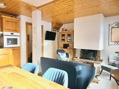 a kitchen and living room with a table and chairs at Charming sunny duplex in Megève