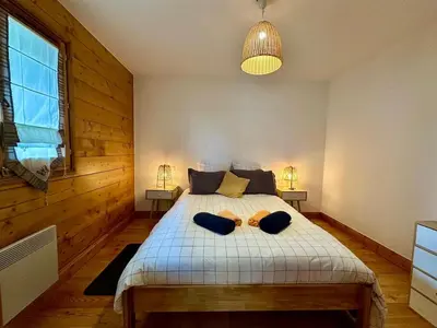 a bedroom with a bed with two towels on it at CoconAlpin au coeur de la station in Arâches-la-Frasse