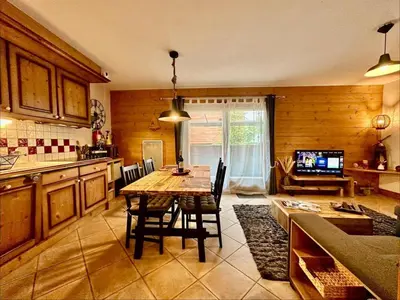 a kitchen with a table and chairs in a room at CoconAlpin au coeur de la station in Arâches-la-Frasse
