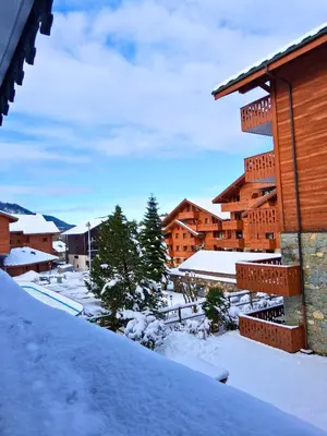 a snow covered yard in front of a building at CoconAlpin au coeur de la station in Arâches-la-Frasse