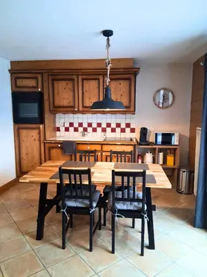 a kitchen with a wooden table and two chairs at CoconAlpin au coeur de la station in Arâches-la-Frasse