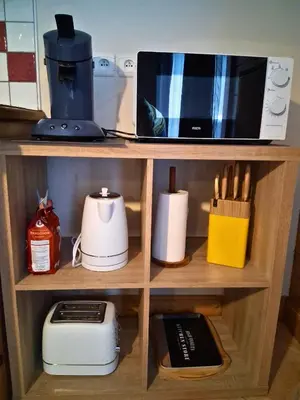 a wooden shelf with a microwave and other kitchen items at CoconAlpin au coeur de la station in Arâches-la-Frasse