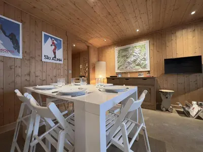 a dining room with a white table and chairs at Le Grison in Megève