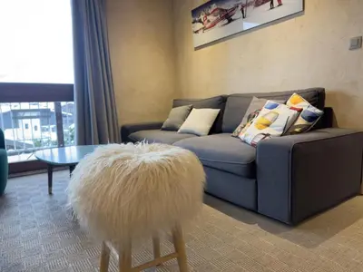 a living room with a couch and a table at Le Grison in Megève
