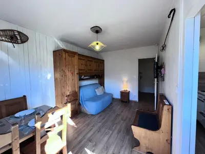 a bedroom with a bed and a blue couch at Résidence Castel Des Roches C - CASTEL DES ROCHES C57 MAE-3063 in Saint-Gervais-les-Bains