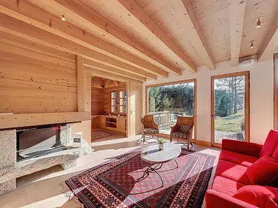 a living room with a red couch and a fireplace at Chalet spacieux 5 chambres proche ski bus, vue Mont-Blanc - FR-1-560-172 in Combloux